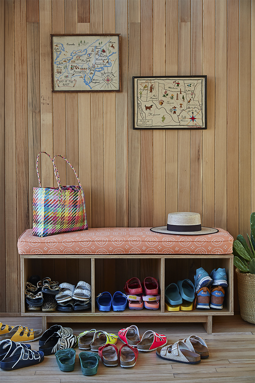 upholstered bench with pile of colorful birkenstocks