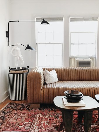 living room with leather sofa and black wall sconce