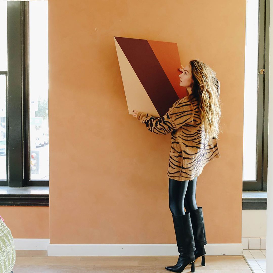 woman holding up a painting