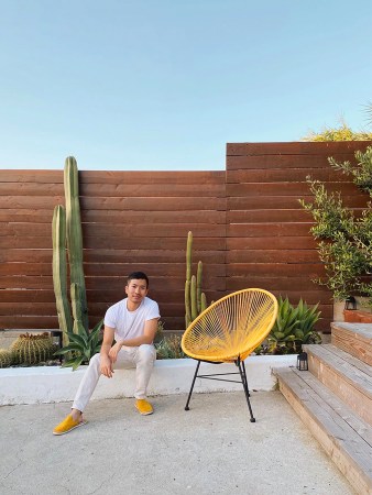 man sitting on wall near garden