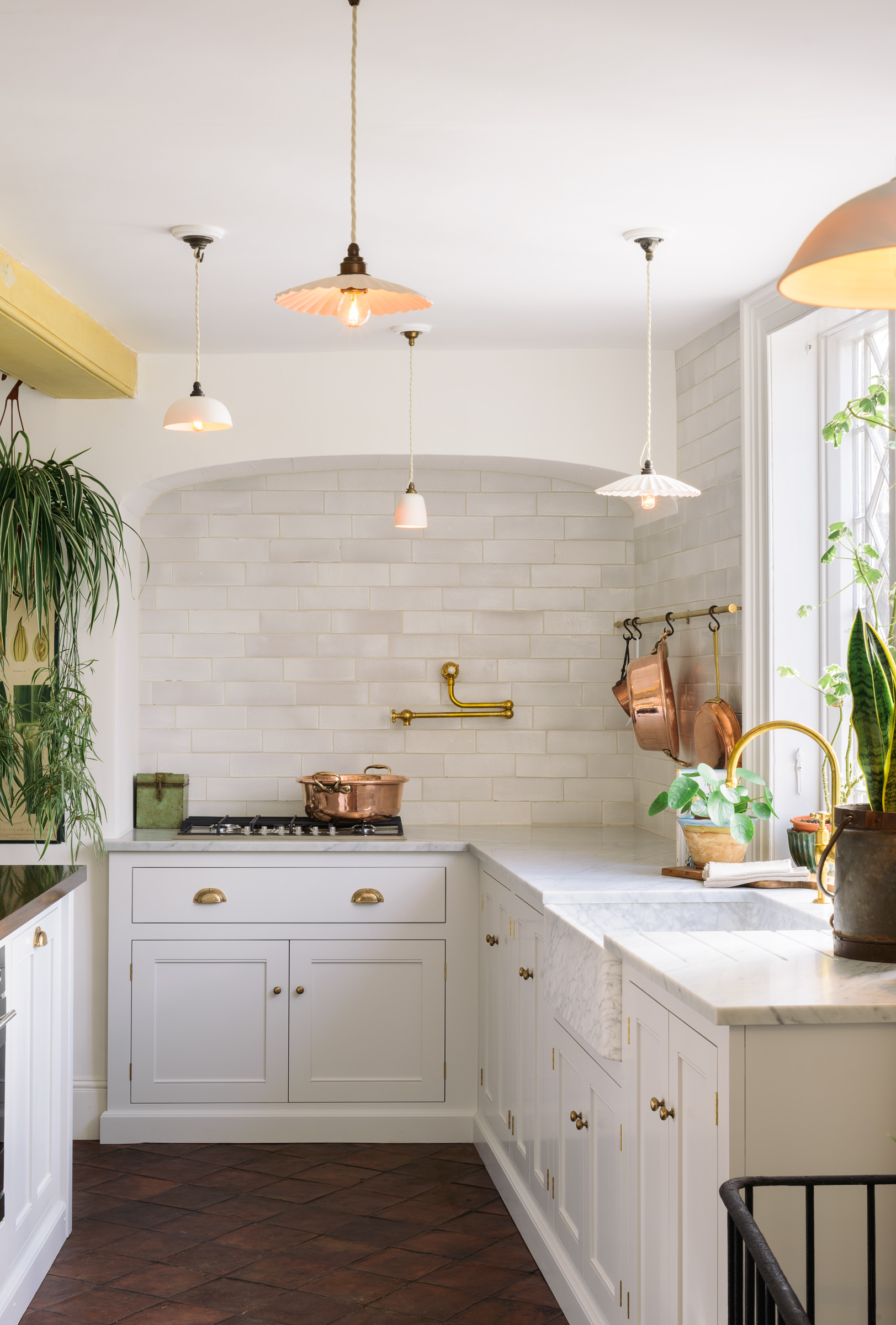 White kitchen with terracotta floors