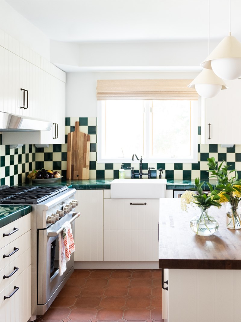 Kitchen with green-and-white backsplash and terracotta floors