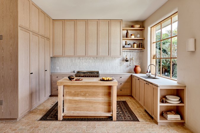 Pale wood kitchen with terracotta floors