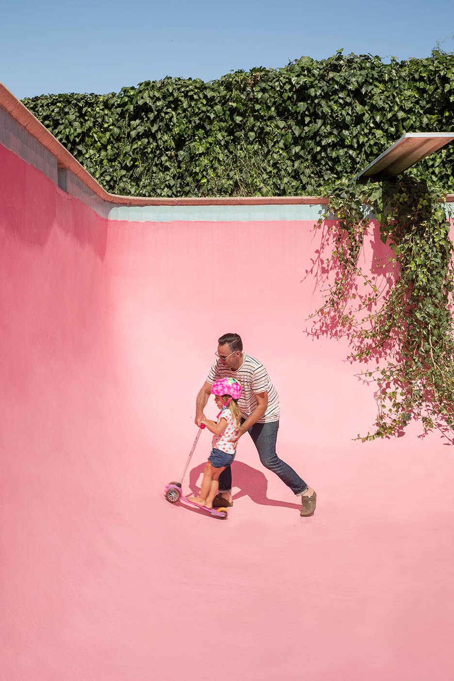 man and kid scootering in pool