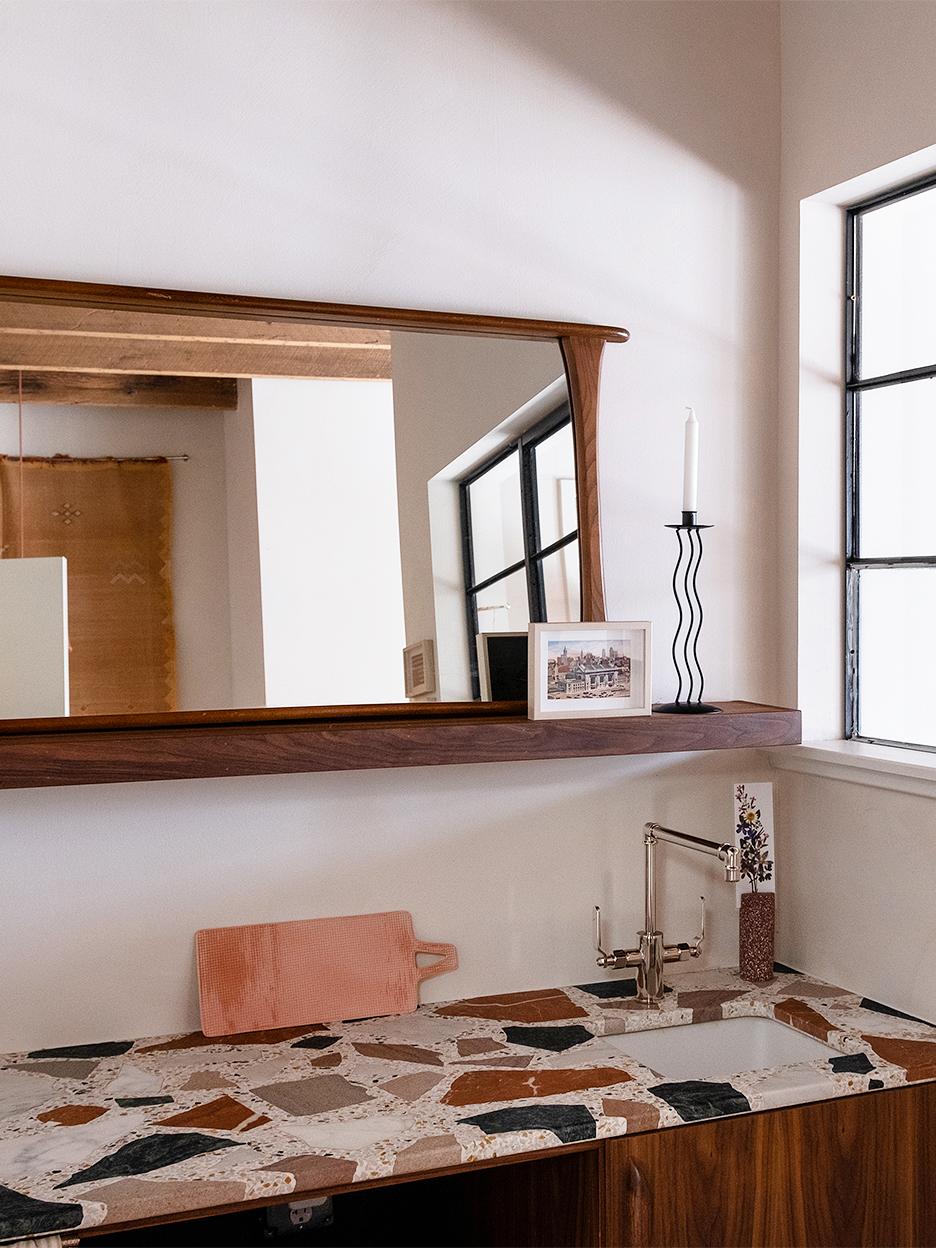 terrazzo counter in kitchenette below mirror