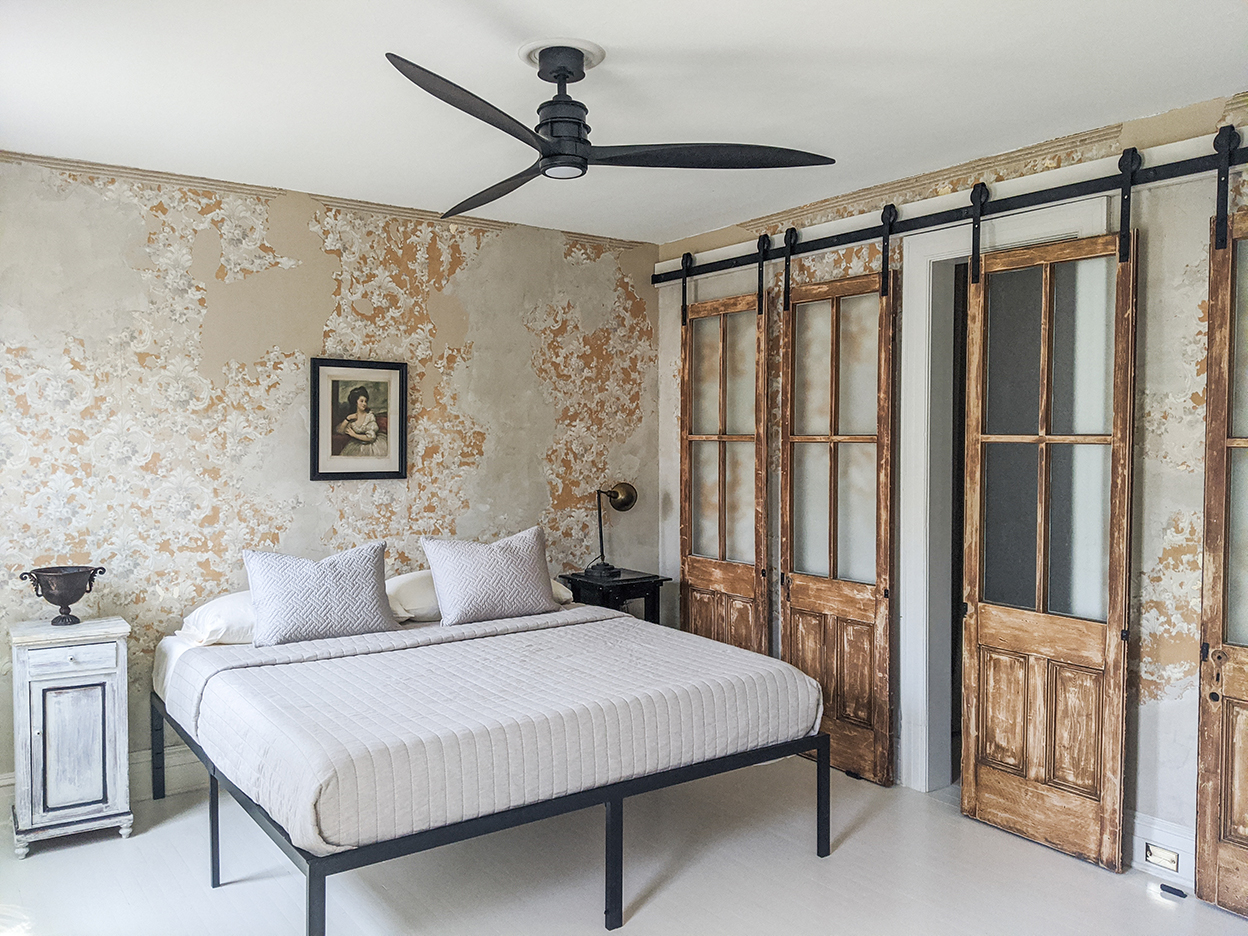 bedroom with black ceiling fan and white bedding