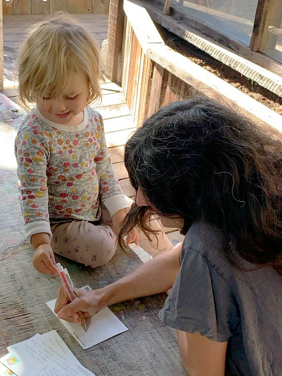 Mother and child writing a postcard