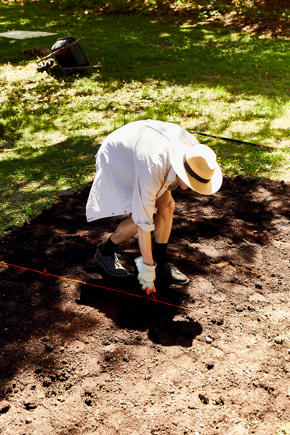 gardener spray painting lines in soil