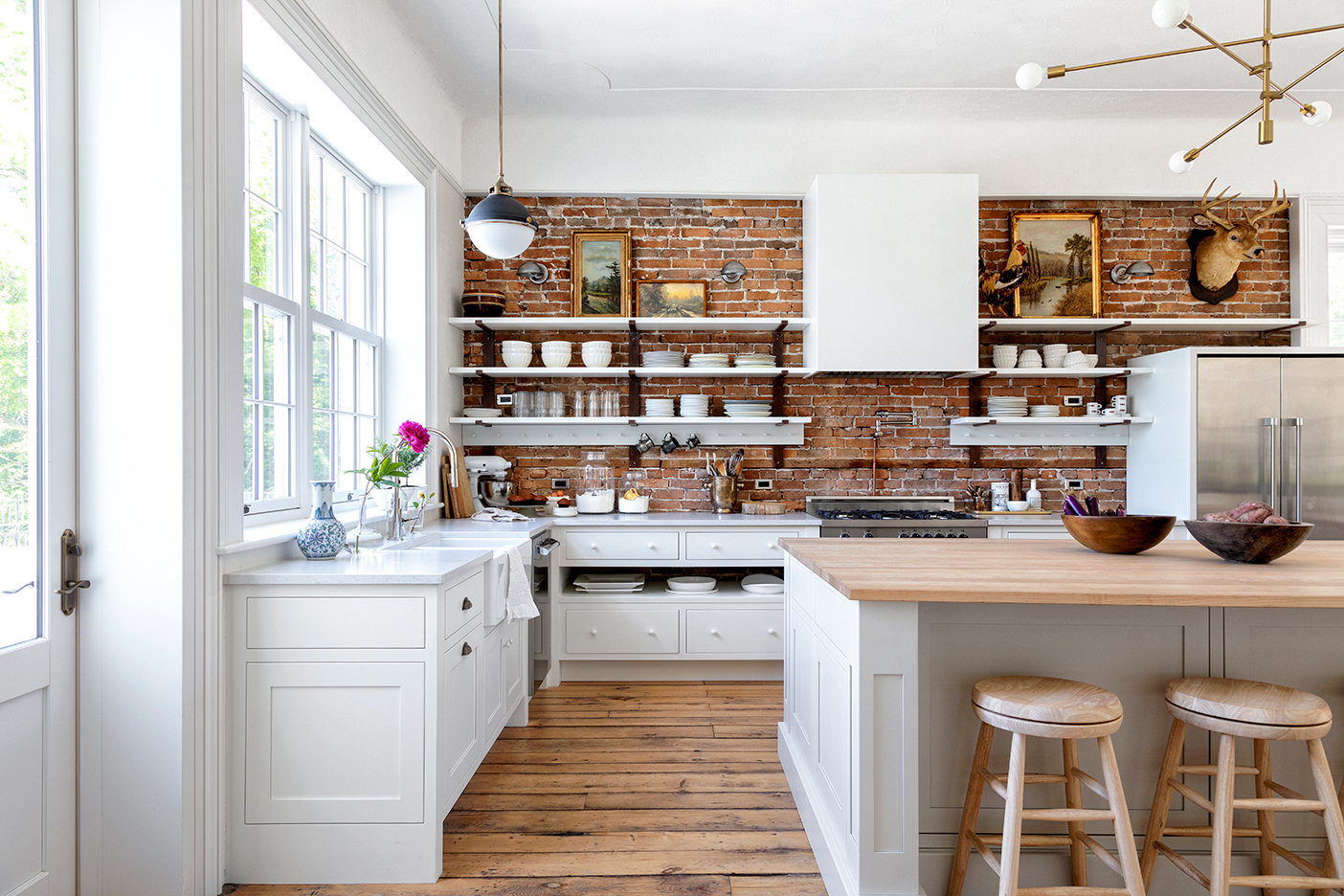 White kitchen with exposed brick walls