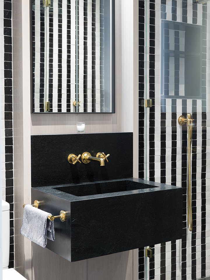 black and white striped tile wall in bathroom black sink