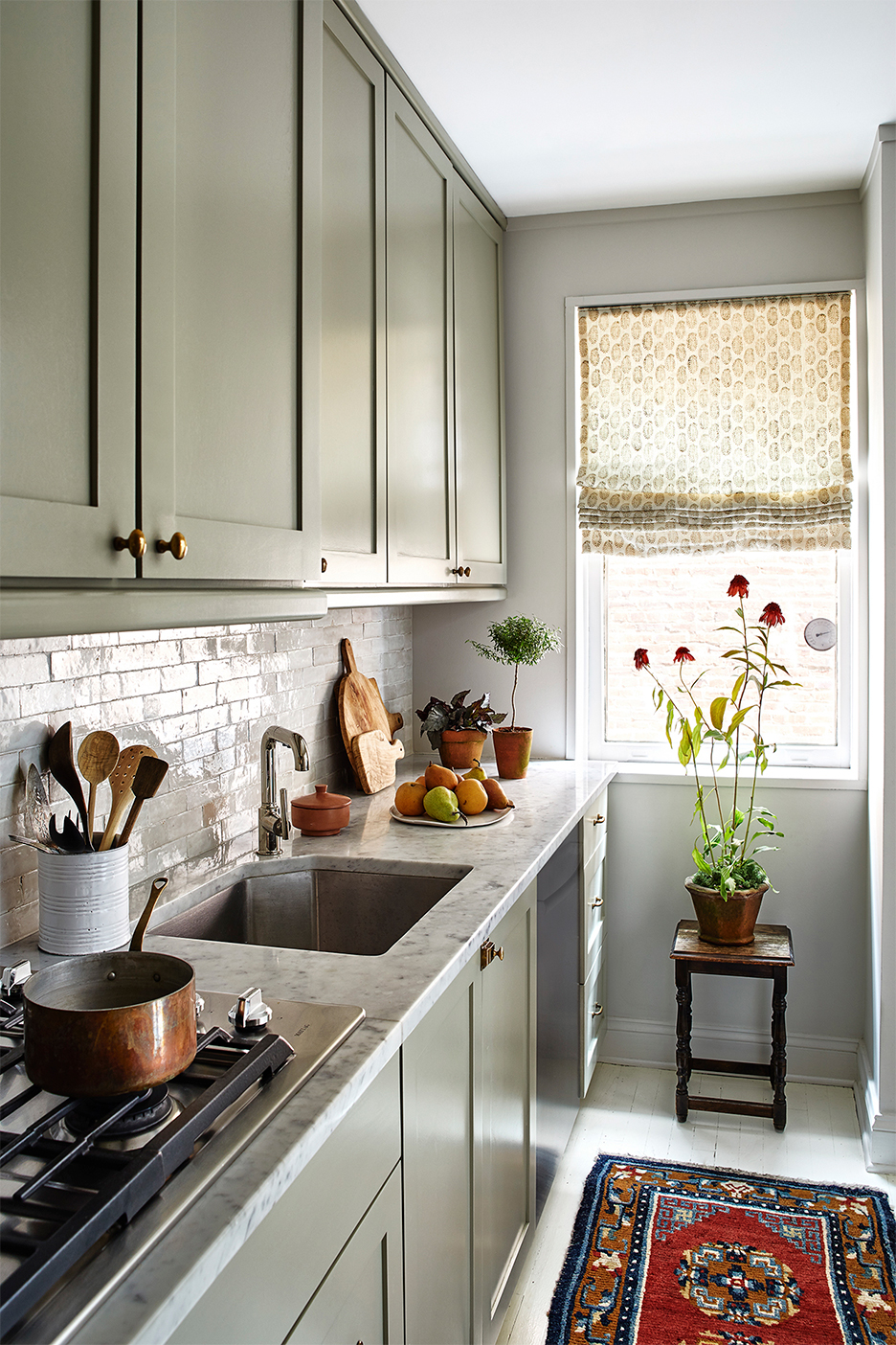 grey-green kitchen with white tile backsplash