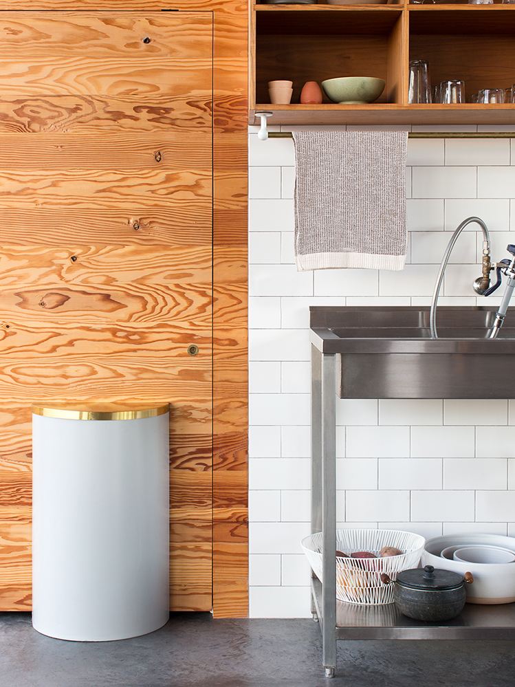 wood kitchen with stainless steel sink that has under shelf