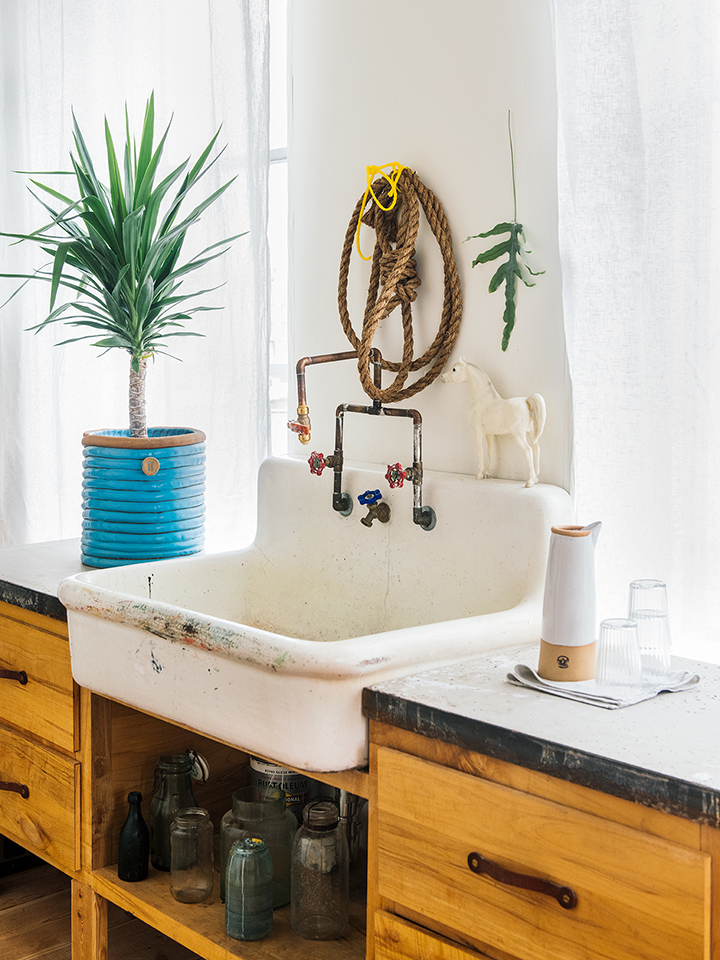 rustic kitchen cabinet sink with glass bottles under it