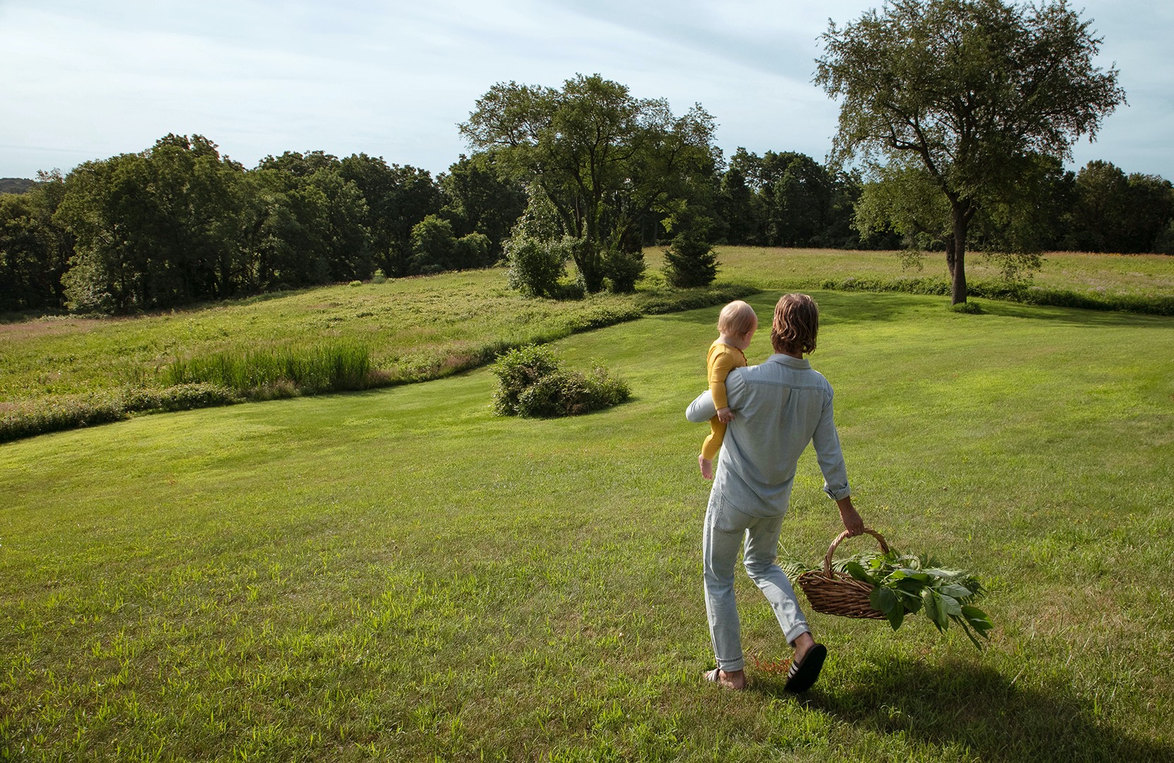 father carrying son on lawn