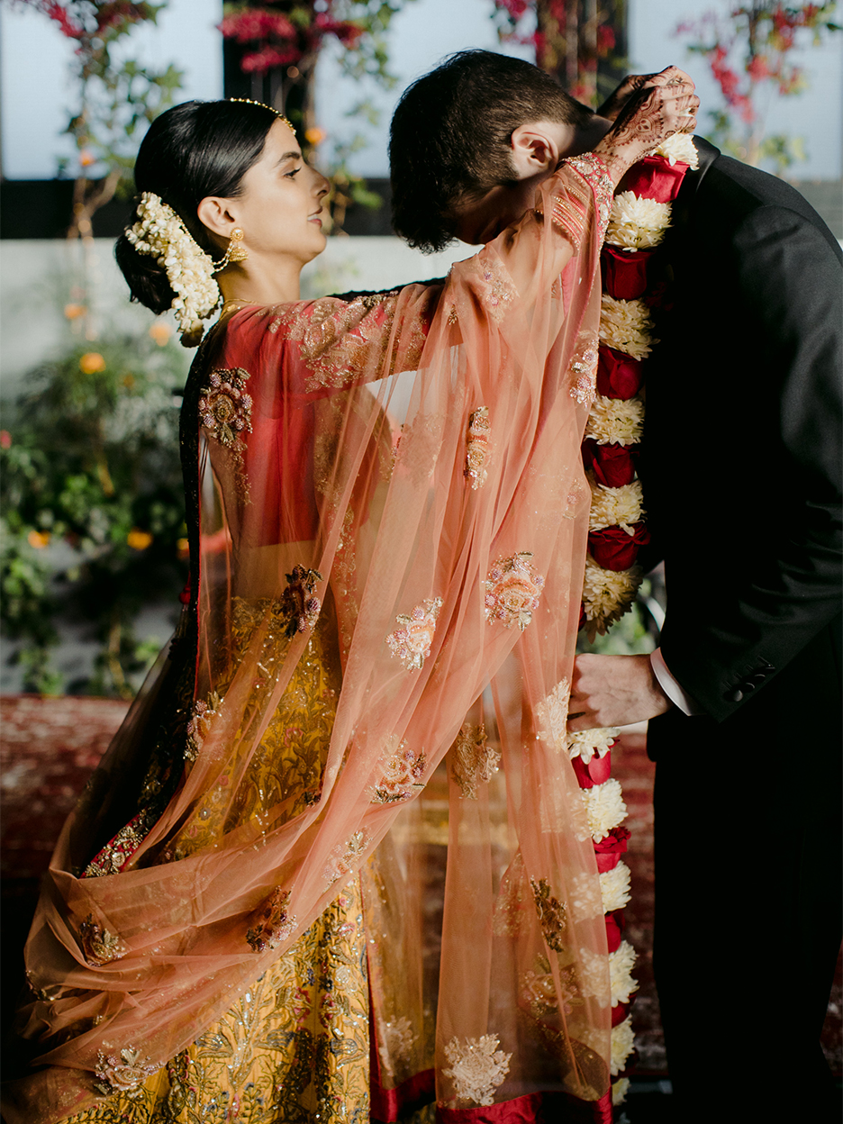 woman placing garland around man