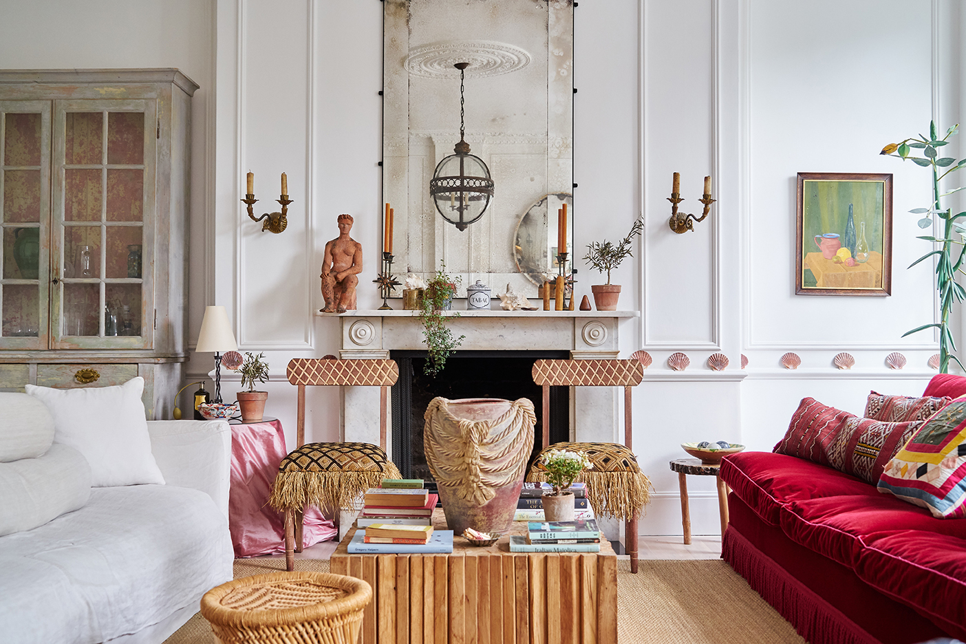 White living room with red velvet sofa