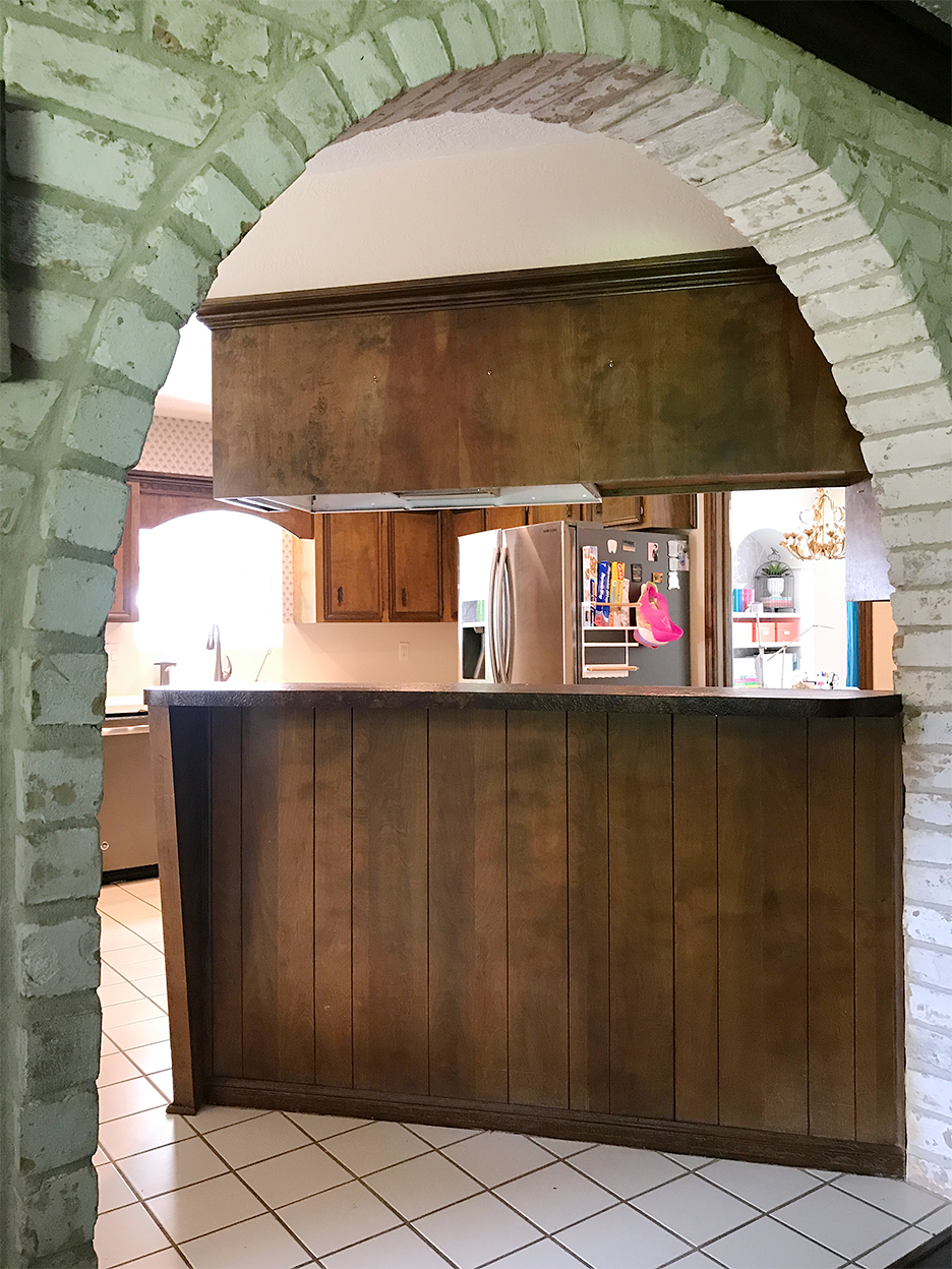 archway leading to brown kitchen