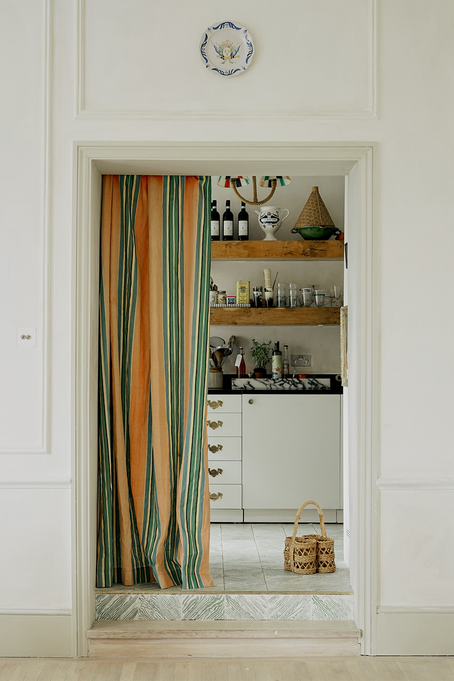 White kitchen behind yellow and green curtain