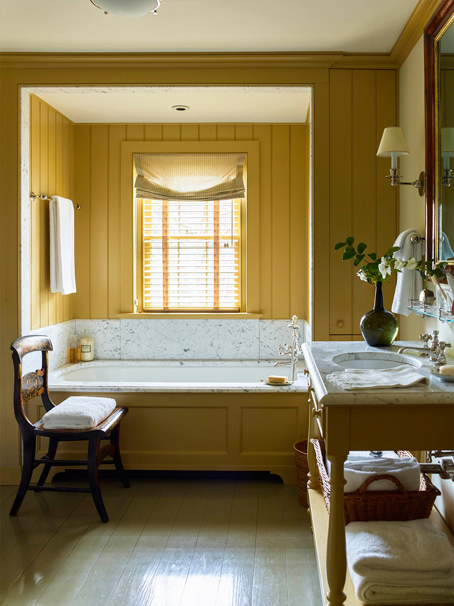 Yellow bathroom with marble tub