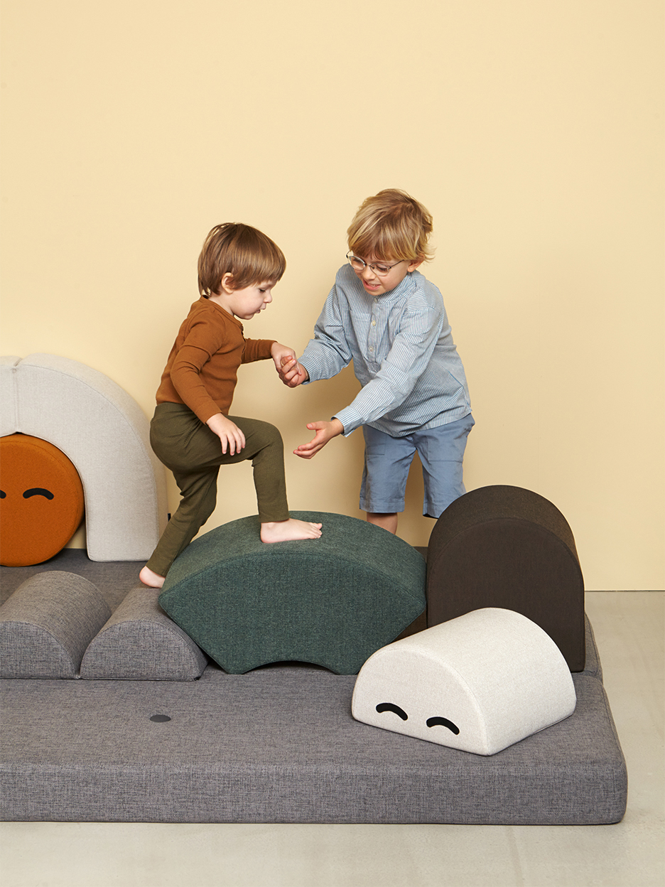 boy climbing on moon shaped cushions