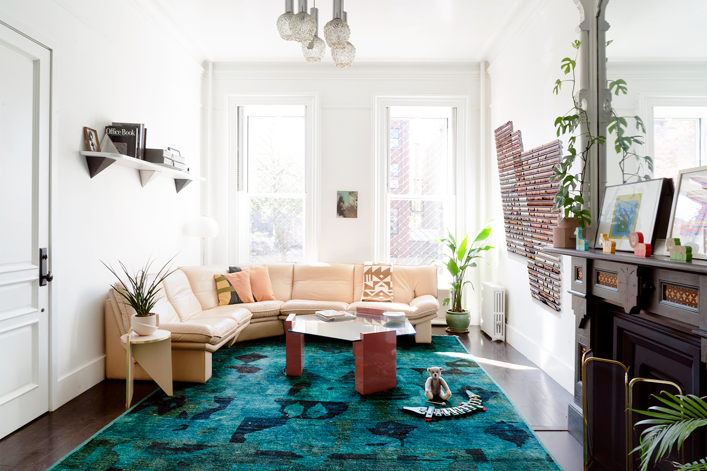 Living room with green rug and beige leather sectional