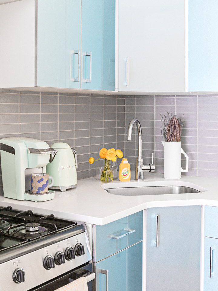 Small kitchen with blue and white cabinet doors.