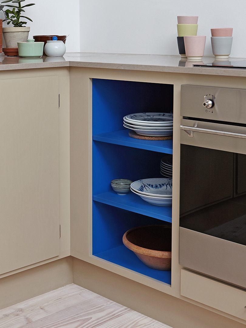 Small kitchen with cobalt blue painted shelves.