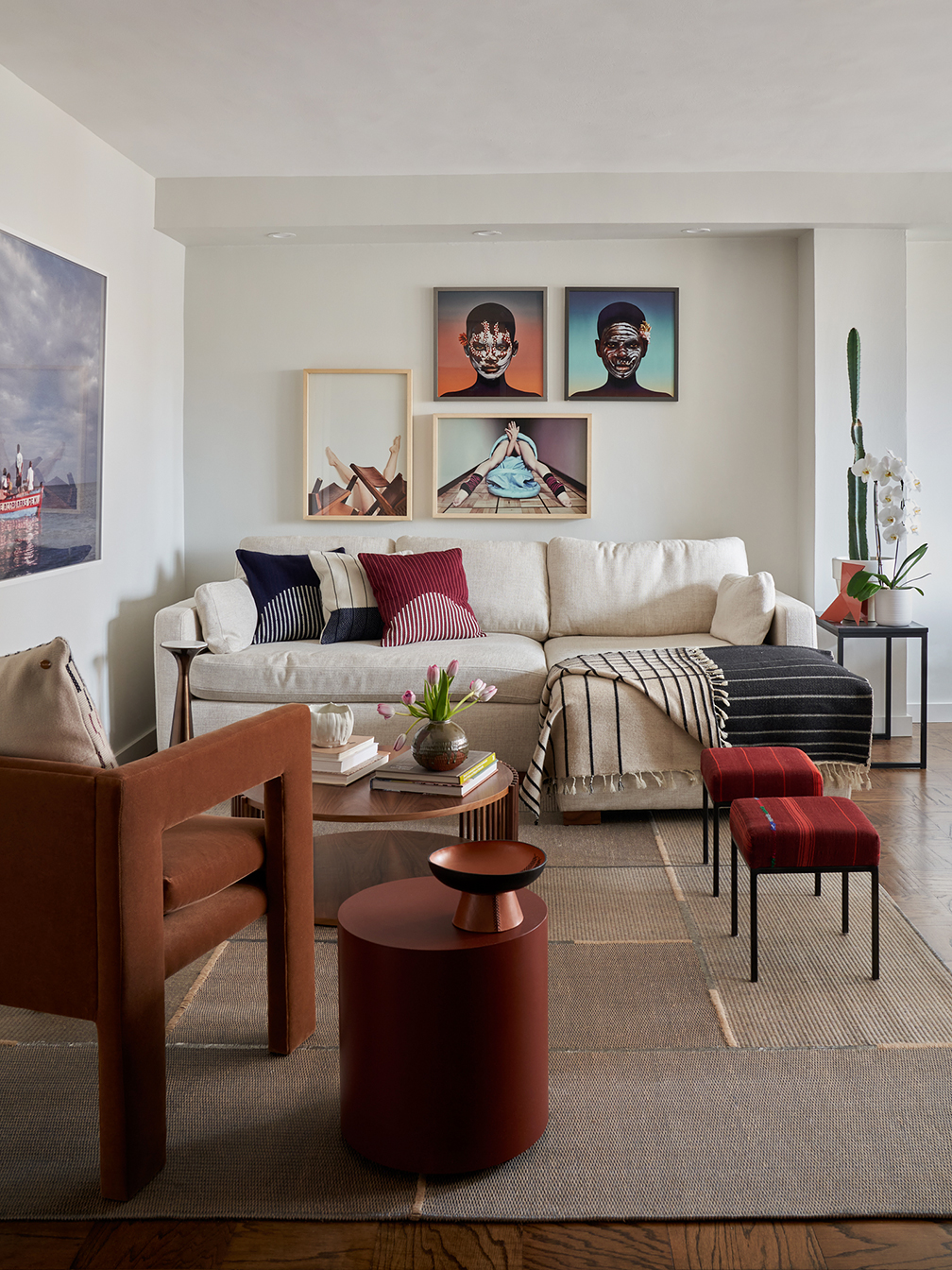 Living room with velvet chair and red stools