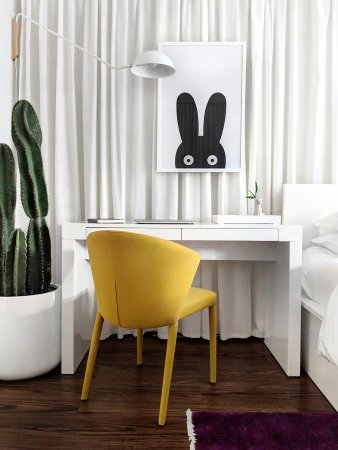 yellow chair and white desk next to bed