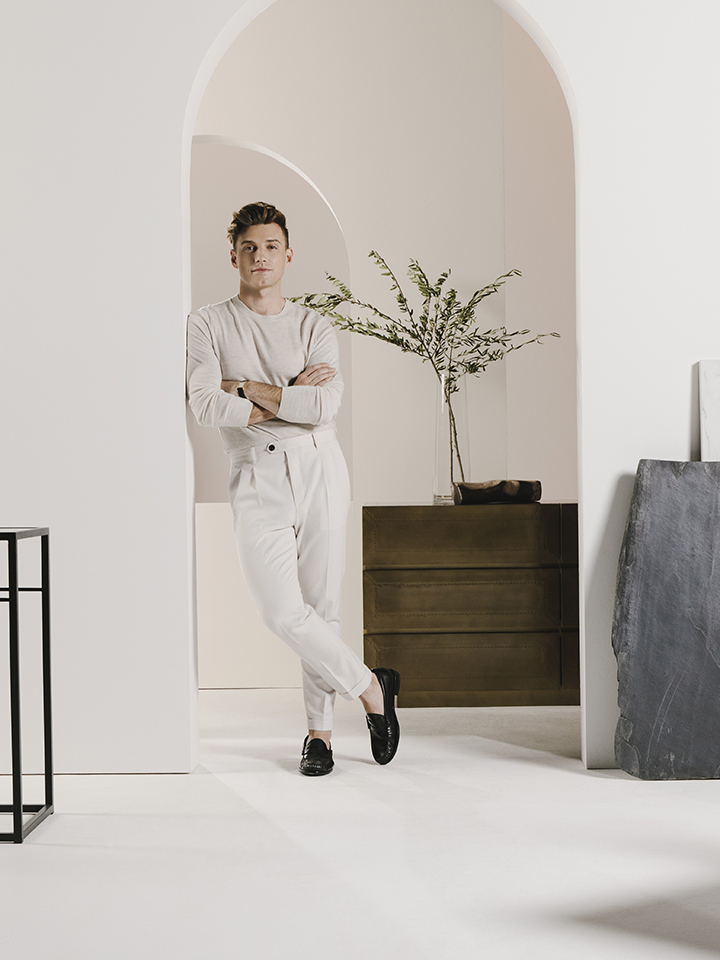 Nate Berkus leaning in a doorway wearing all white