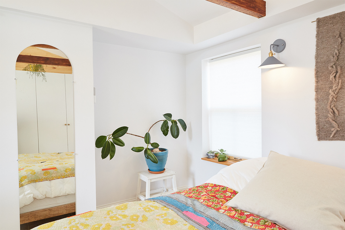 white bedroom with plant on table