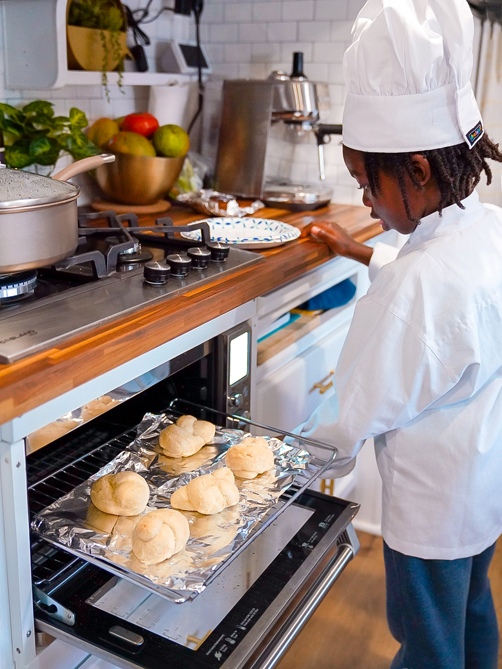 boy baking buns in the oven