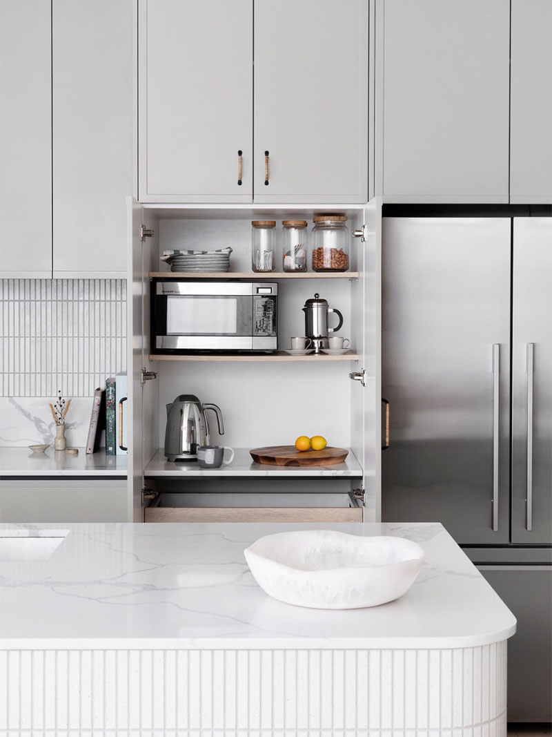 grey kitchen with open appliance cabinet doors