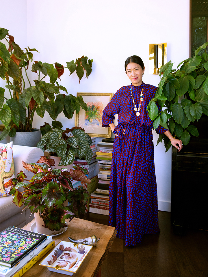 Woman in purple dress surrounded by houseplants