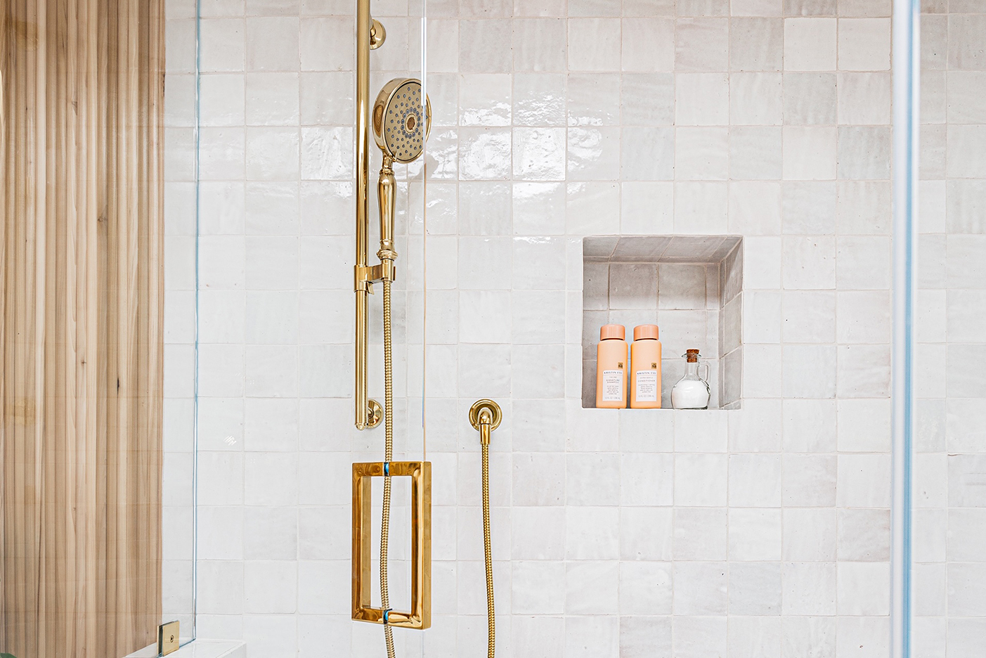 brass shower facuet around whit tiles