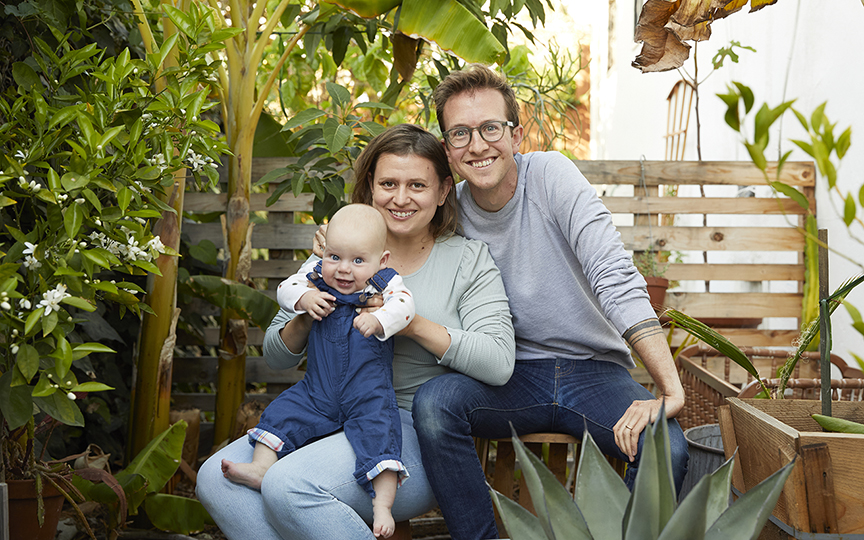 Couple holding baby in backyard garden