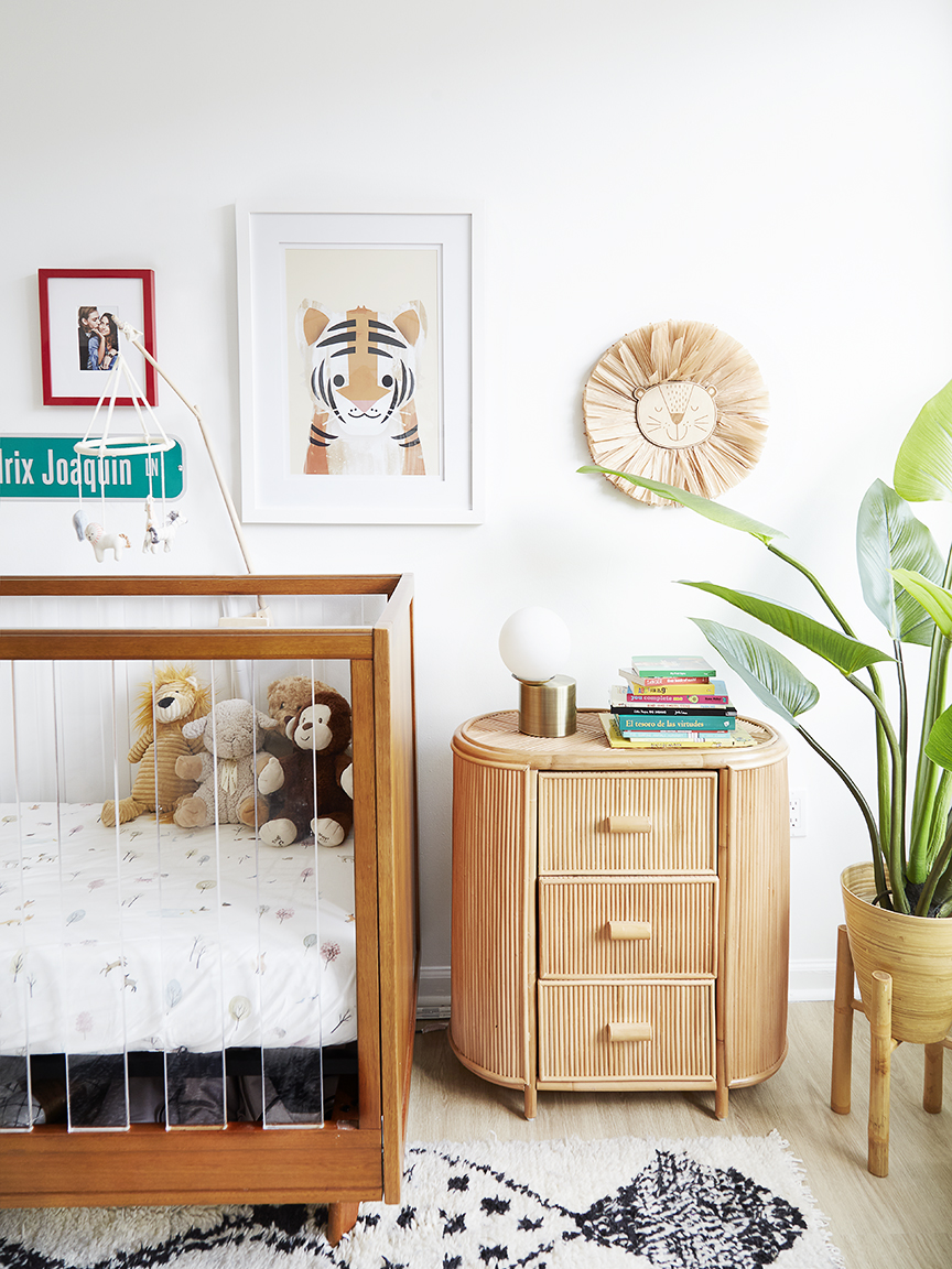 teak crib next to rattan dresser