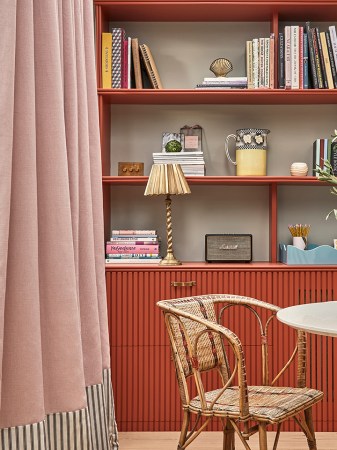 Red living room cabinet with a pleated lampshade on it