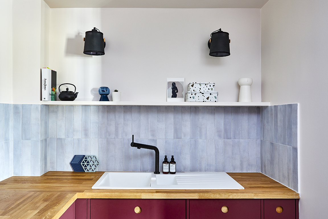 sink with gray backsplash and open shelf