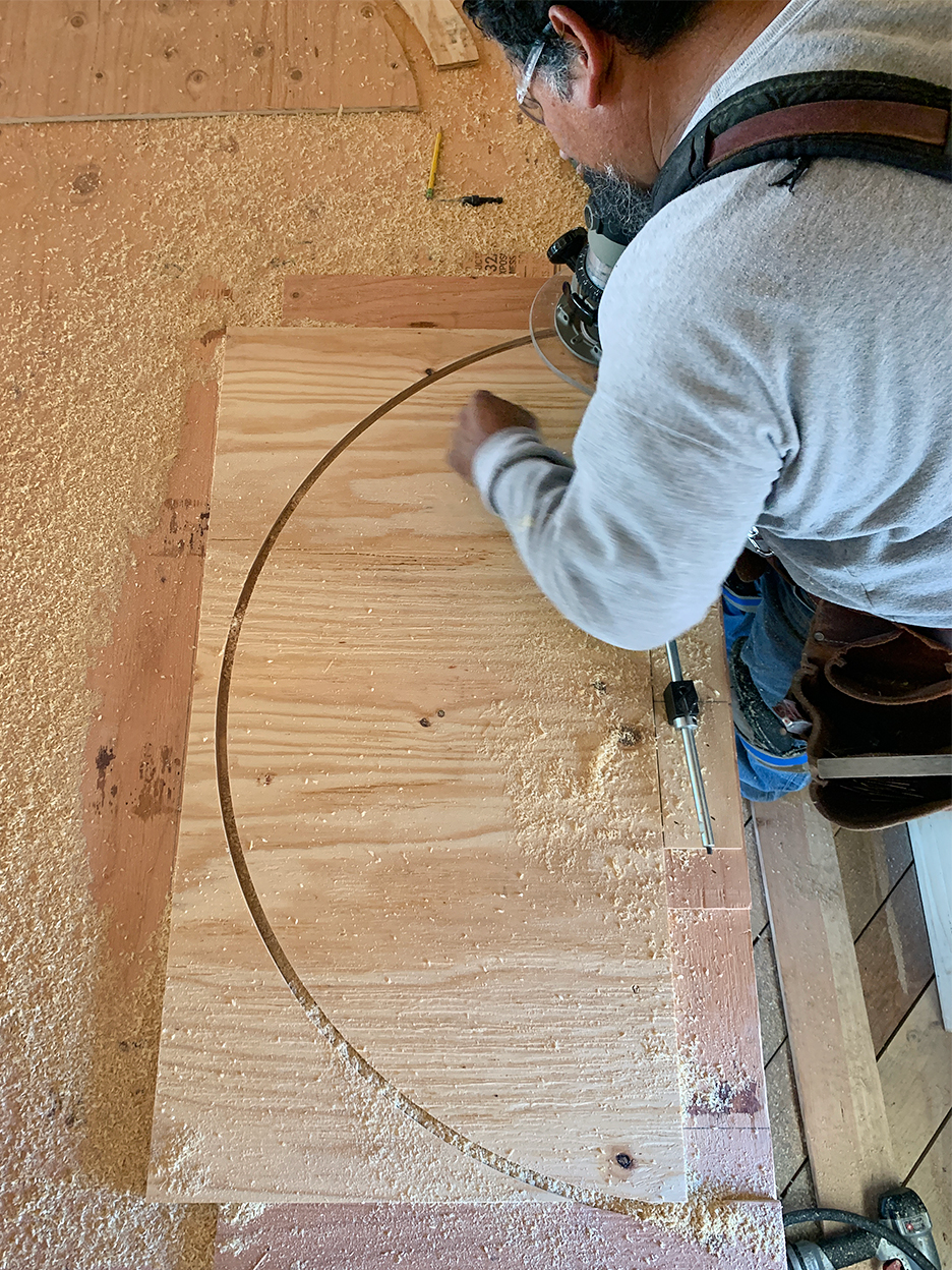 man cutting arch in wood