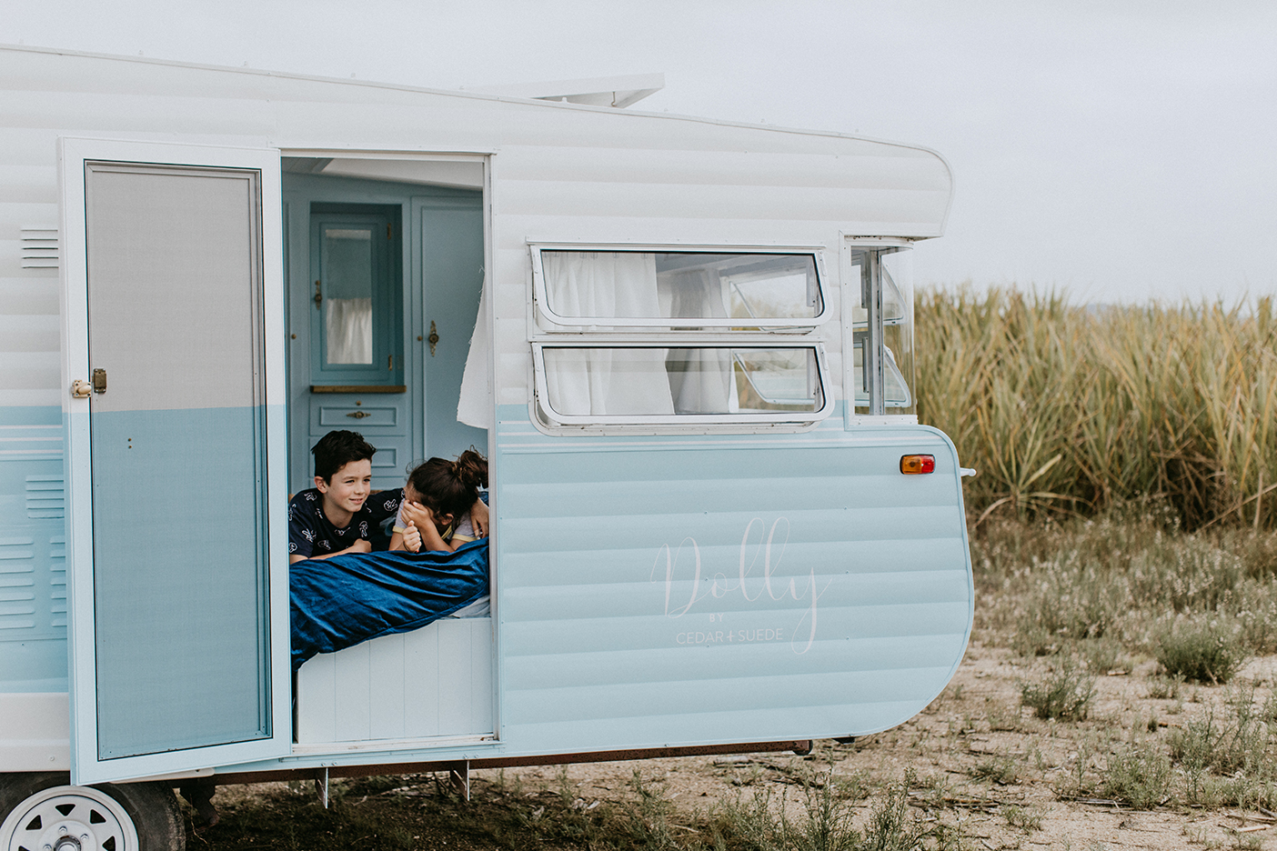 kids on bed in van with door open