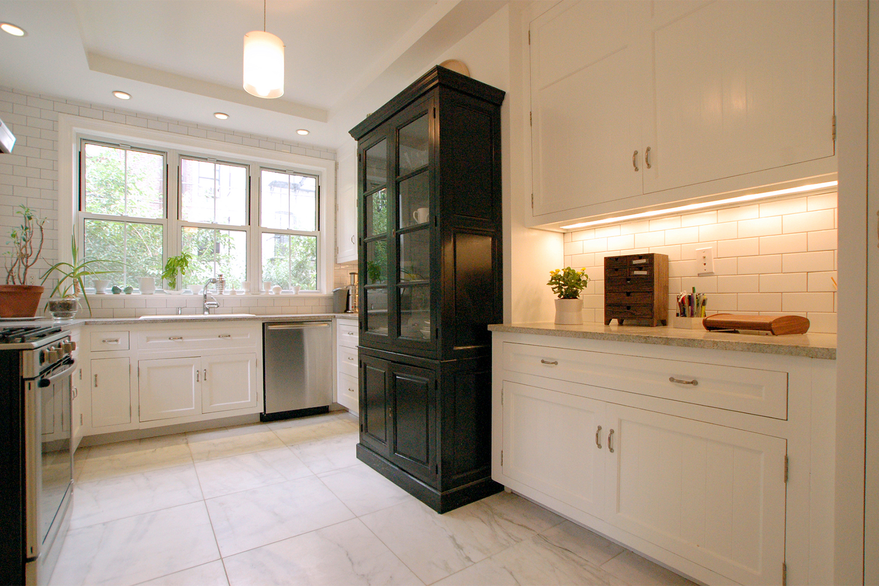 white kitchen with one dark storage cabinet