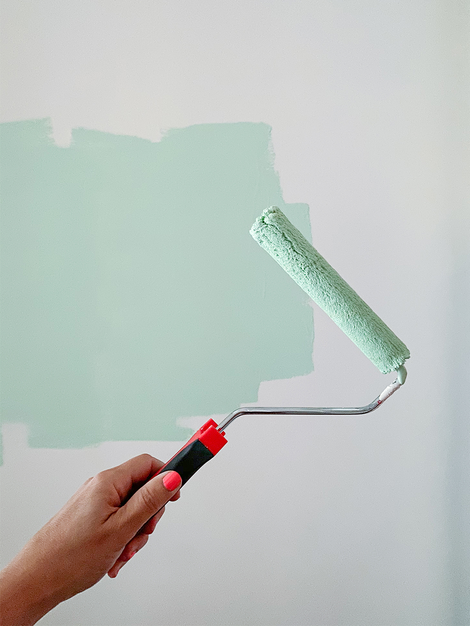 womans hand holding paint roller