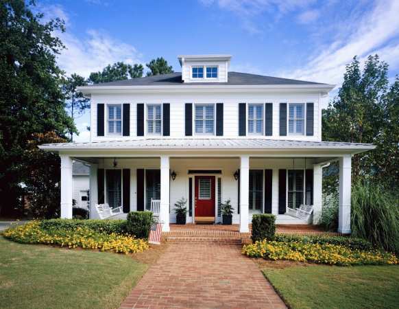 white house with porch and red door