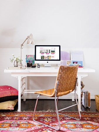 white desk with computer and woven brown chair