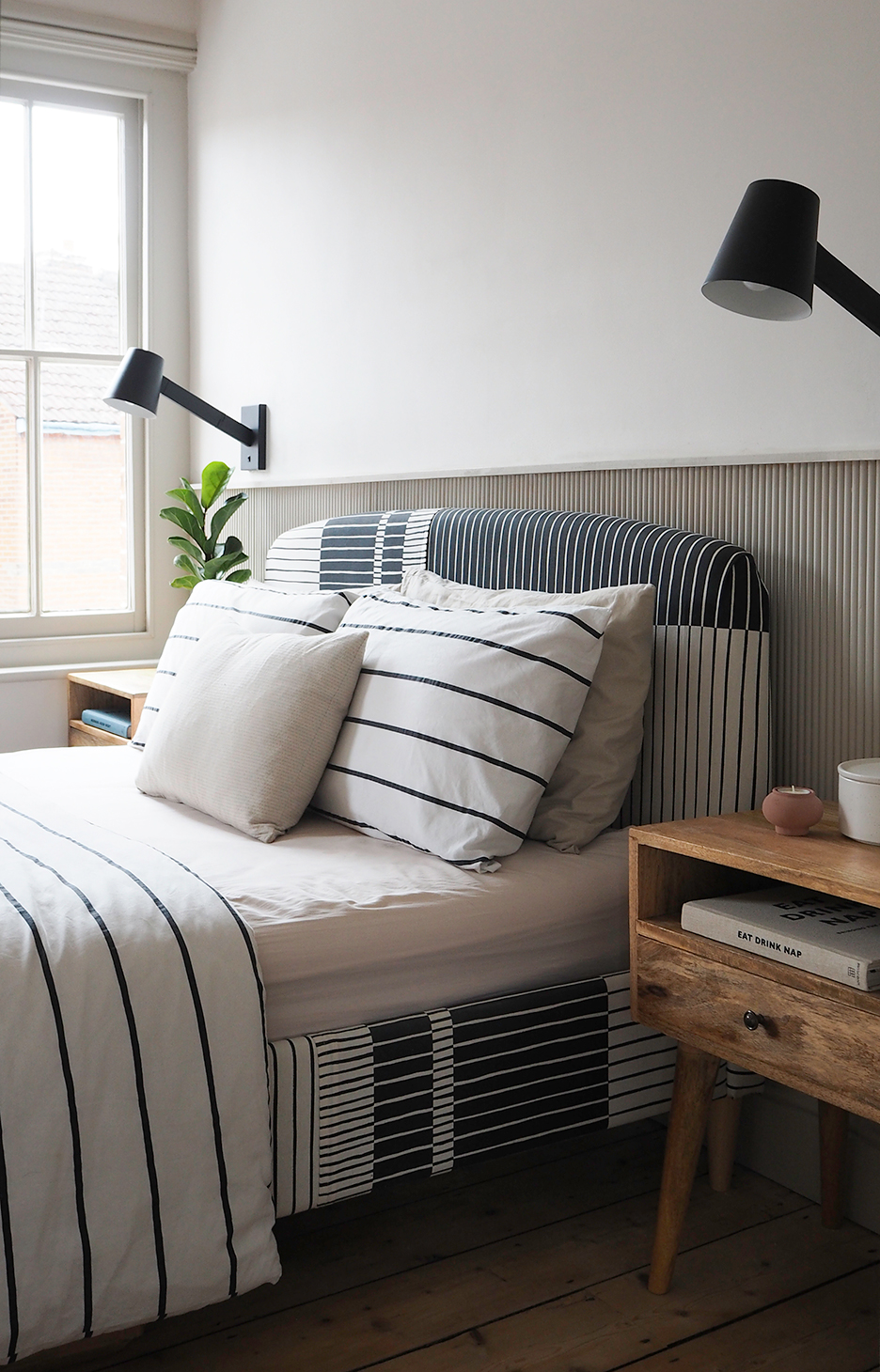 side view of striped upholstered bedframe with striped bedding