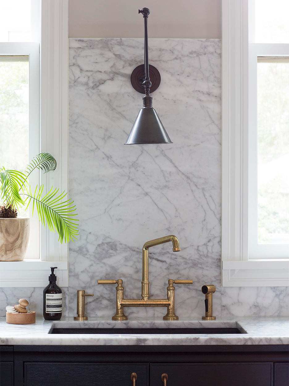 kitchen sink area with marble countertop and backsplash