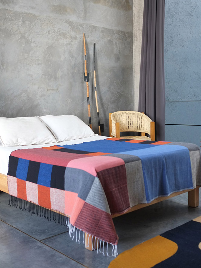 bed with colorful colorblocked blanket