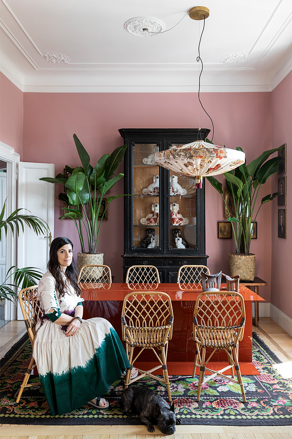 Dining room with pink walls and woman with dog