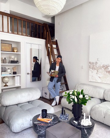 man standing in living room next to loft ladder